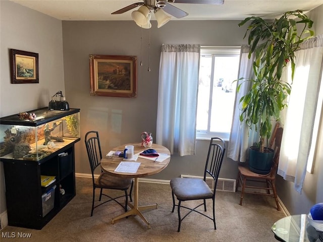 carpeted dining area with ceiling fan