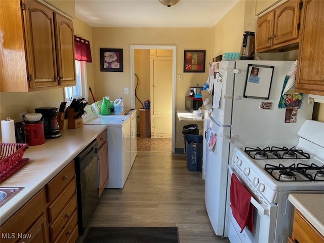 kitchen with dark hardwood / wood-style floors, washer and clothes dryer, and black appliances