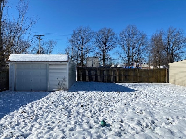 snowy yard with an outbuilding and a garage