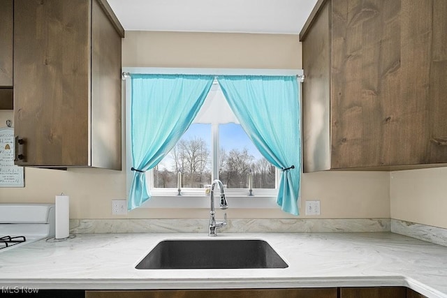 kitchen featuring dark brown cabinets and sink