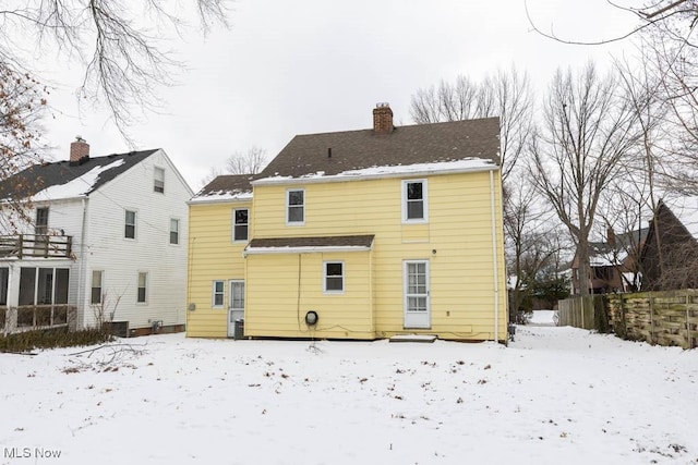 snow covered back of property with central AC