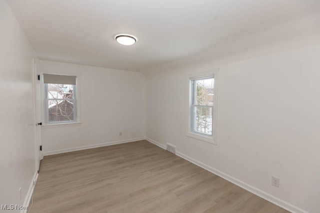 spare room with light wood-type flooring and a wealth of natural light