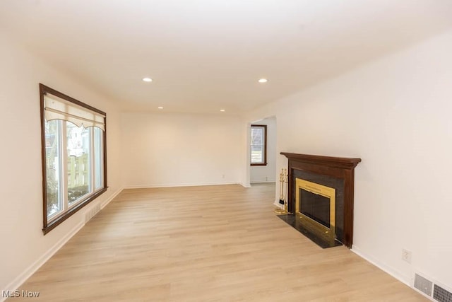 unfurnished living room featuring a healthy amount of sunlight and light hardwood / wood-style floors