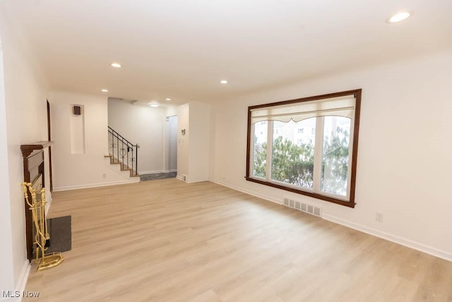 unfurnished living room with a fireplace and light hardwood / wood-style flooring