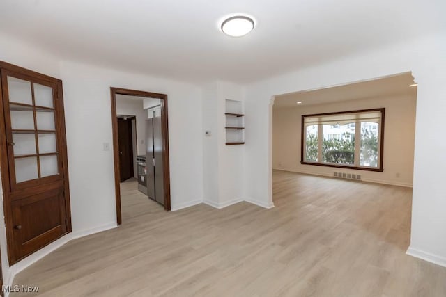 empty room with light hardwood / wood-style flooring