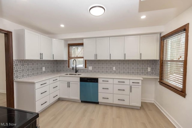 kitchen with white cabinets, sink, stainless steel dishwasher, light wood-type flooring, and a wealth of natural light