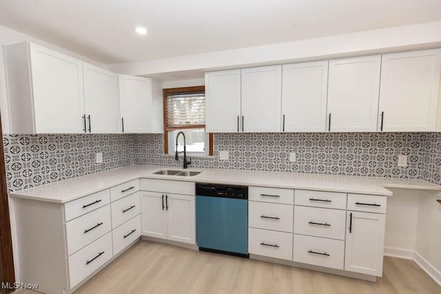 kitchen featuring light wood-type flooring, white cabinets, backsplash, sink, and dishwasher