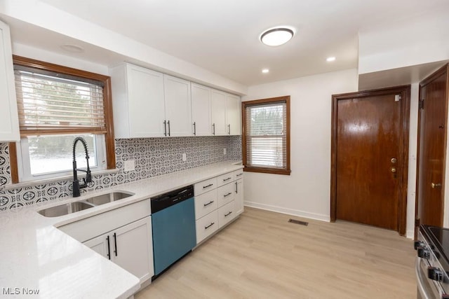 kitchen featuring white cabinets, sink, light hardwood / wood-style flooring, a healthy amount of sunlight, and stainless steel appliances