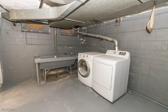 clothes washing area with sink and independent washer and dryer