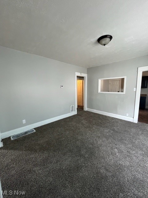 carpeted spare room with a textured ceiling