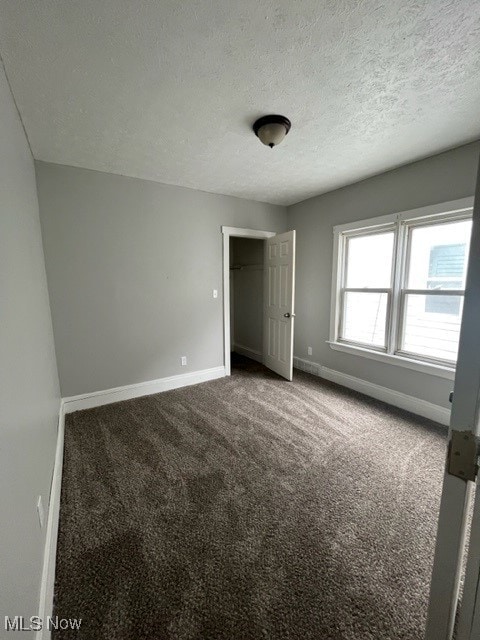 unfurnished bedroom with a textured ceiling and carpet flooring