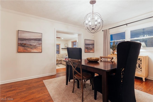 dining space featuring a chandelier, hardwood / wood-style floors, and crown molding