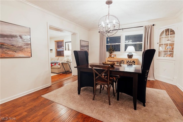 dining room with a chandelier, hardwood / wood-style flooring, and crown molding