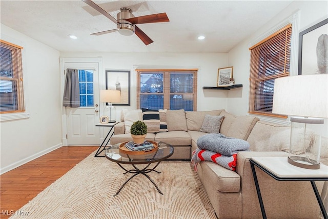 living room with light hardwood / wood-style flooring and ceiling fan