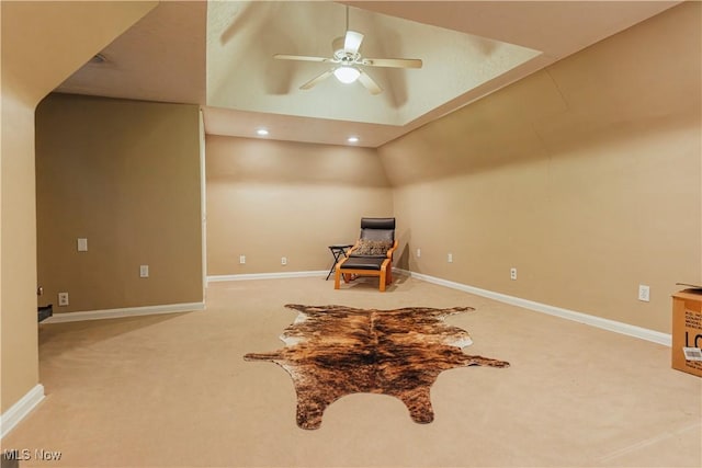 living area featuring ceiling fan, carpet floors, and lofted ceiling