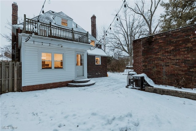 snow covered property with a balcony