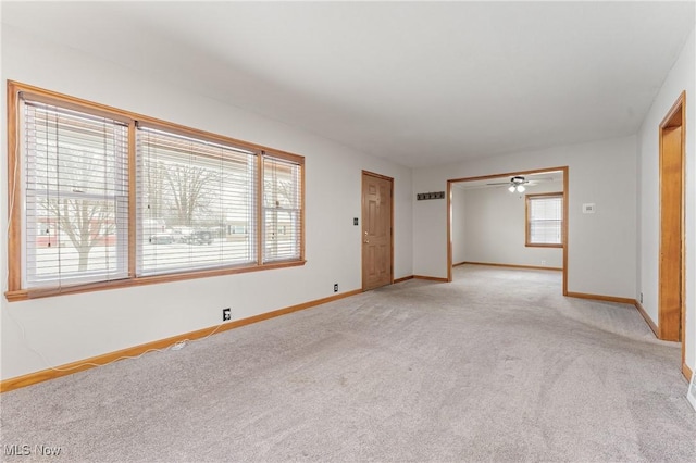 unfurnished room featuring light carpet and ceiling fan