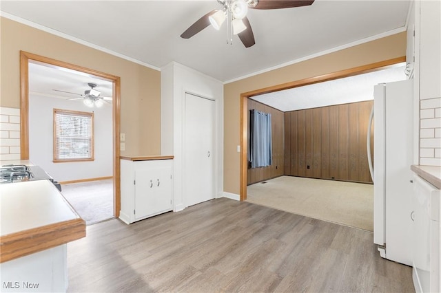 interior space featuring crown molding, light hardwood / wood-style flooring, and ceiling fan