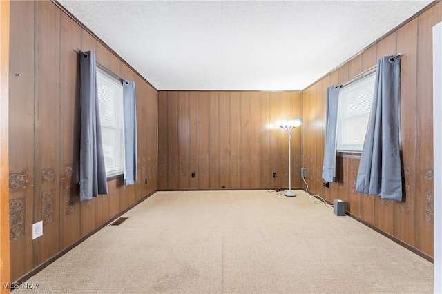 unfurnished room featuring light colored carpet, crown molding, and wood walls