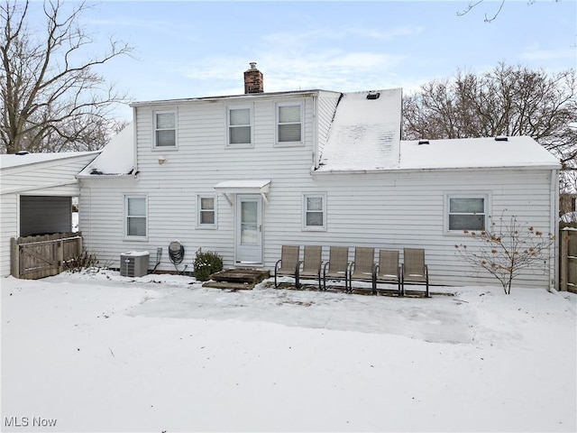 snow covered property with central AC unit