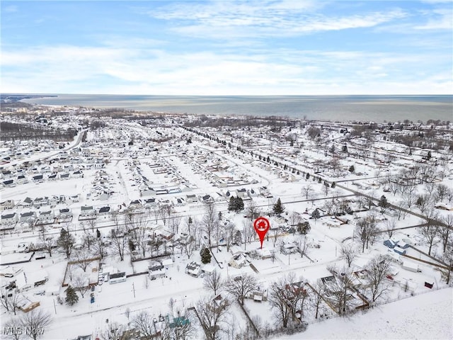 snowy aerial view with a water view