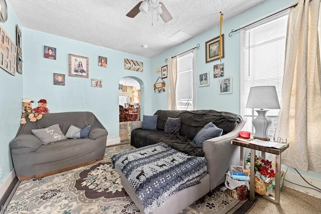 living room with carpet flooring, a textured ceiling, and ceiling fan