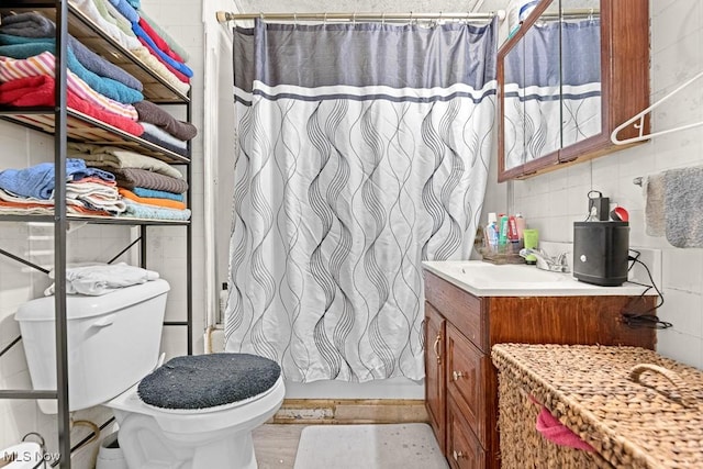 bathroom with a shower with shower curtain, vanity, and toilet