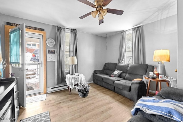 living room featuring a baseboard radiator, ceiling fan, a healthy amount of sunlight, and light hardwood / wood-style floors