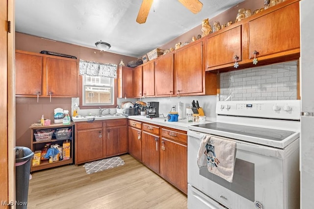 kitchen featuring decorative backsplash, ceiling fan, sink, electric range, and light hardwood / wood-style flooring