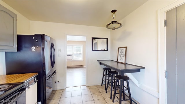 kitchen featuring gray cabinetry, stainless steel electric stove, light tile patterned floors, and a baseboard radiator