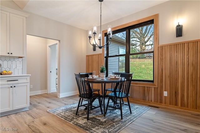 dining space featuring a healthy amount of sunlight, light wood-type flooring, and an inviting chandelier