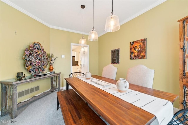 dining room with crown molding and carpet floors