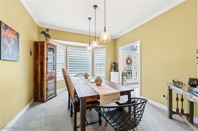 dining room featuring crown molding and light carpet