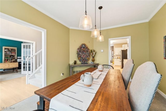 carpeted dining space with crown molding