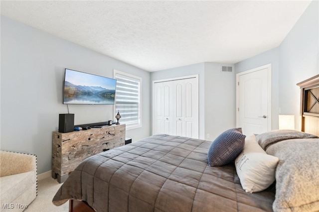 carpeted bedroom featuring a closet and a textured ceiling