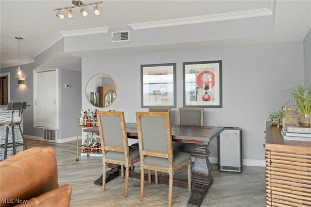 dining room with hardwood / wood-style flooring and crown molding