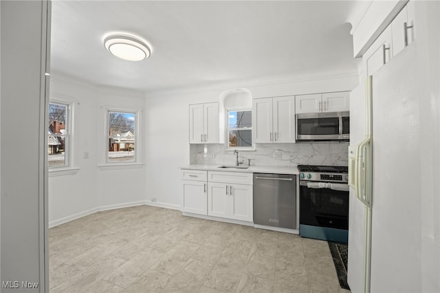 kitchen featuring white cabinets, sink, appliances with stainless steel finishes, and tasteful backsplash