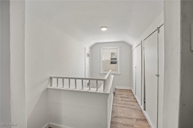 corridor featuring light hardwood / wood-style floors and lofted ceiling