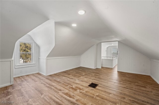 bonus room featuring light wood-type flooring and lofted ceiling