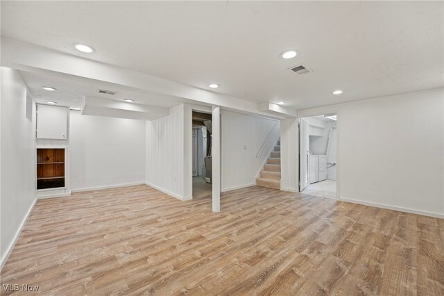 basement with washer and dryer and light wood-type flooring