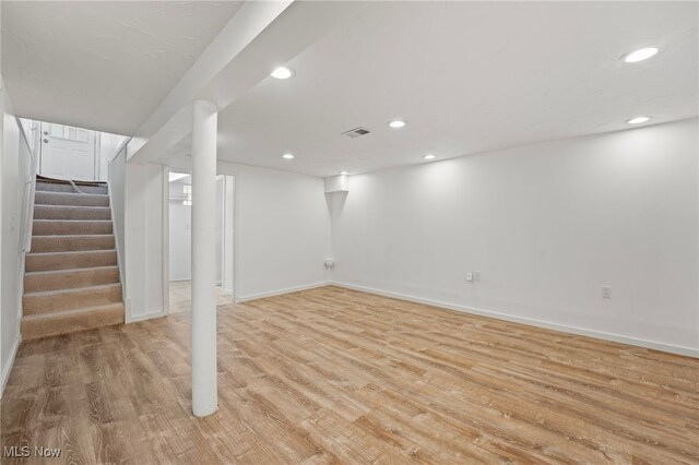 basement with light hardwood / wood-style flooring