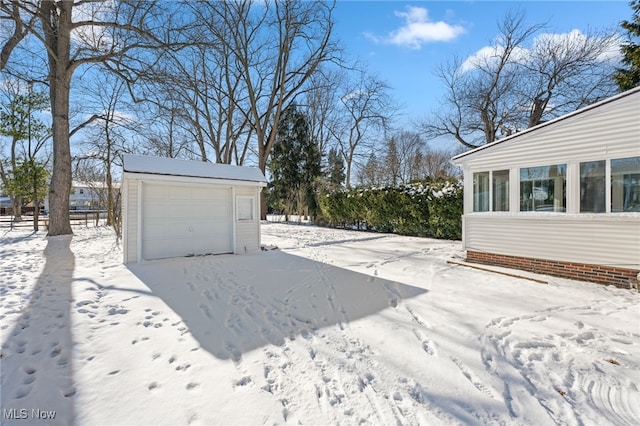 yard covered in snow with an outdoor structure and a garage