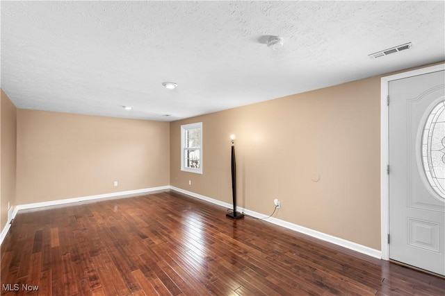 foyer featuring a textured ceiling and dark hardwood / wood-style flooring