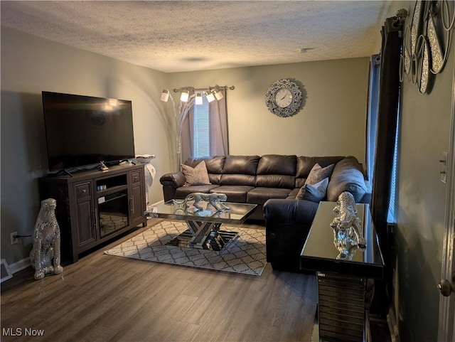 living room with dark wood-type flooring and a textured ceiling