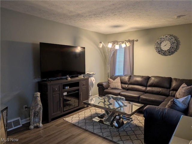 living room with wood-type flooring and a textured ceiling