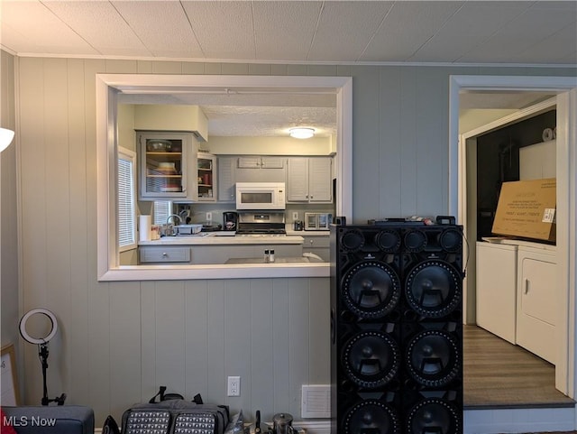 kitchen featuring white cabinetry, independent washer and dryer, and hardwood / wood-style floors