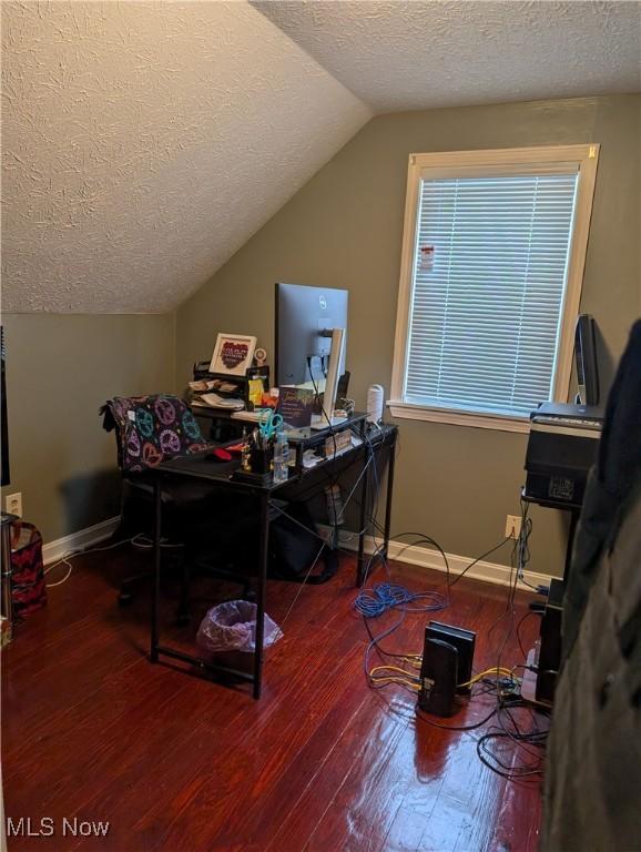 home office with hardwood / wood-style floors, vaulted ceiling, and a textured ceiling