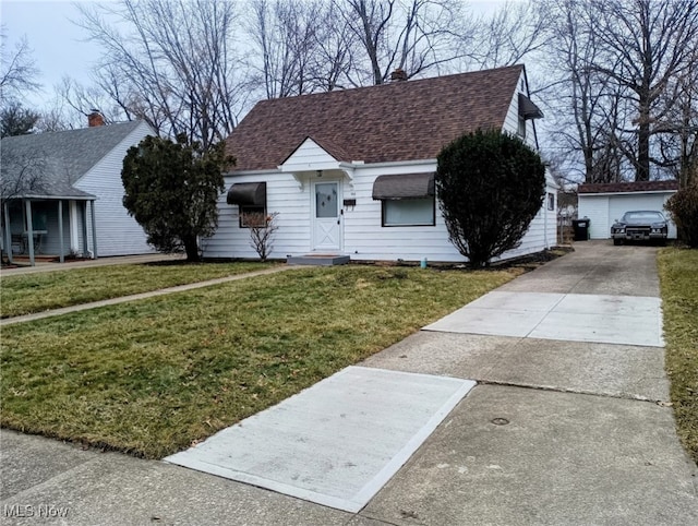 view of front of home with an outbuilding, a garage, and a front lawn