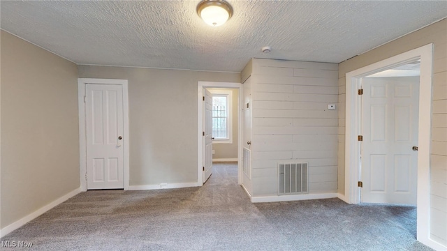 unfurnished room featuring carpet floors and a textured ceiling