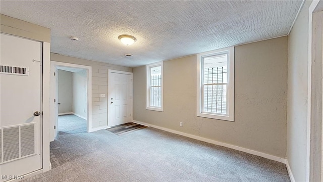 carpeted spare room with a textured ceiling